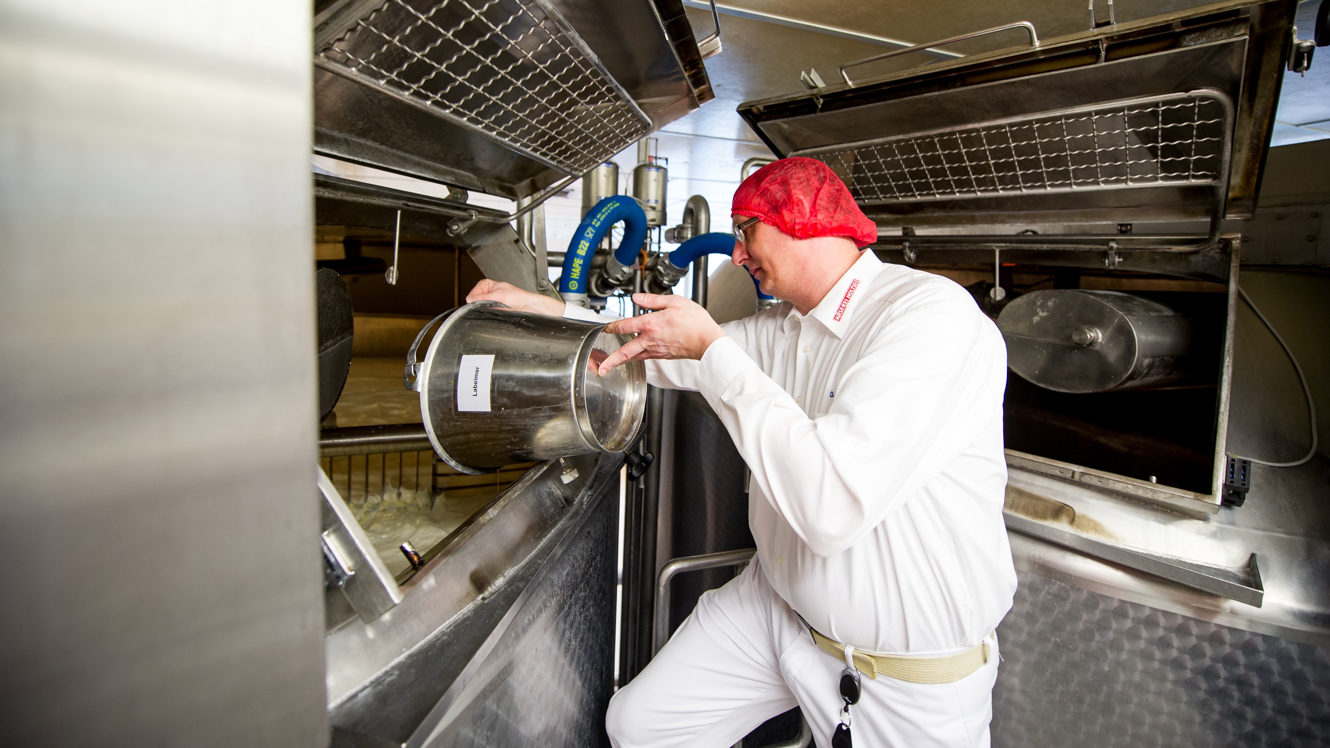 Ein Mann fügt Lab zur Milch dazu